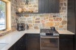 Rustic meets modern in this spacious kitchen with beautiful stone backsplash.